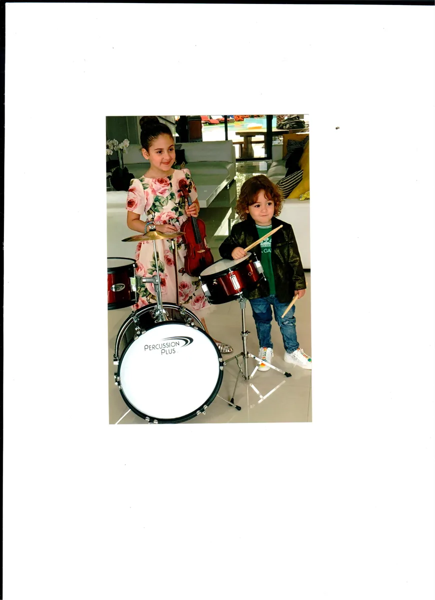 Two children playing a drum set together